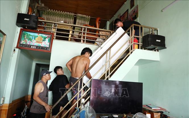 Người dân thành phố Lào Cai di chuyển tài sản lên tầng cao khi nước lũ sắp tràn vào nhà. Ảnh: Quốc Khánh - TTXVN