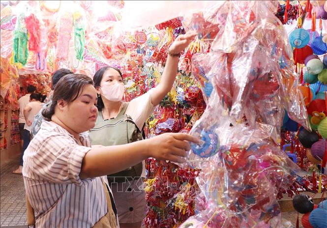 Người dân lựa chọn các mẫu lồng đèn về trang trí cho căn nhà. Ảnh: Thu Hương - TTXVN