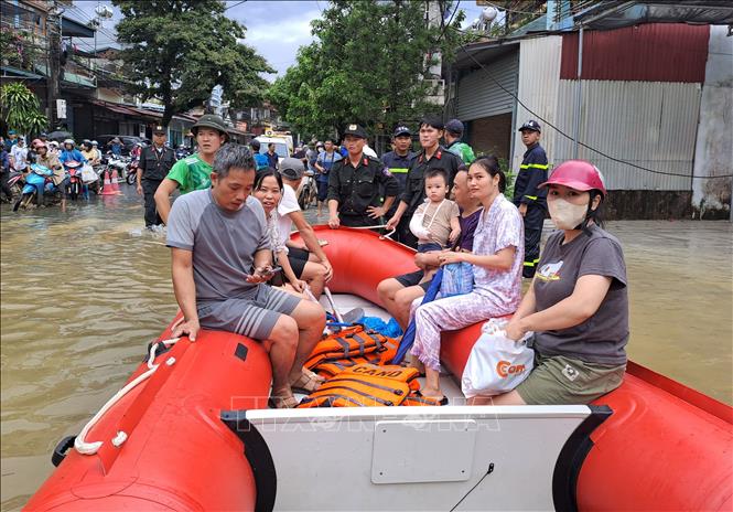 Lực lượng công an cùng chính quyền địa phương di dời người dân đến nơi an toàn. Ảnh: Đức Thọ - TTXVN.