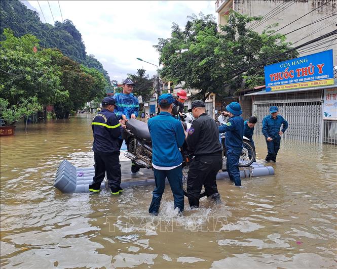Lực lượng công an cùng chính quyền địa phương di dời người dân đến nơi an toàn. Ảnh: Đức Thọ - TTXVN.