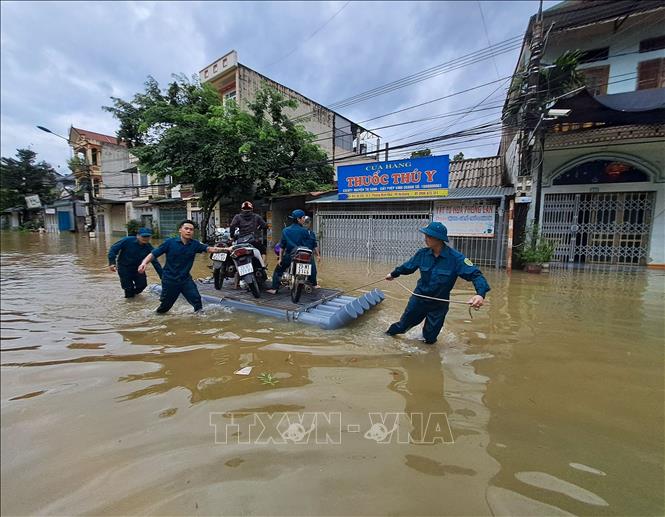  Lực lượng công an cùng chính quyền địa phương di dời người dân đến nơi an toàn. Ảnh: Đức Thọ - TTXVN