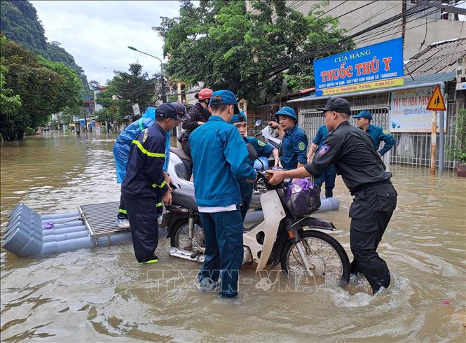 Lực lượng công an cùng chính quyền địa phương di dời người dân đến nơi an toàn. Ảnh: Đức Thọ - TTXVN