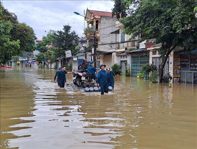  Lực lượng công an cùng chính quyền địa phương di dời người dân đến nơi an toàn. Ảnh: Đức Thọ - TTXVN