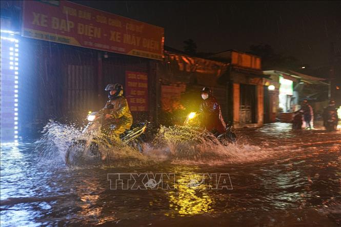 Mưa kéo dài nhiều giờ đồng hồ khiến nhiều tuyến phố ngập sâu trong nước. Ảnh: Phạm Tuấn Anh - TTXVN