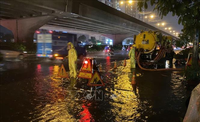 Nhân viên Công ty thoát nước ứng trực, kịp thời tổ chức tiêu thoát nước trên đường Nguyễn Xiển, quận Thanh Xuân. Ảnh: Nguyễn Thắng - TTXVN