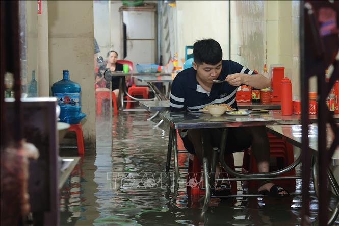 Một quán cơm trên đường Triều Khúc (quận Thanh Xuân) nước ngập sâu vào trong nhà. Ảnh: Hoàng Hiếu - TTXVN