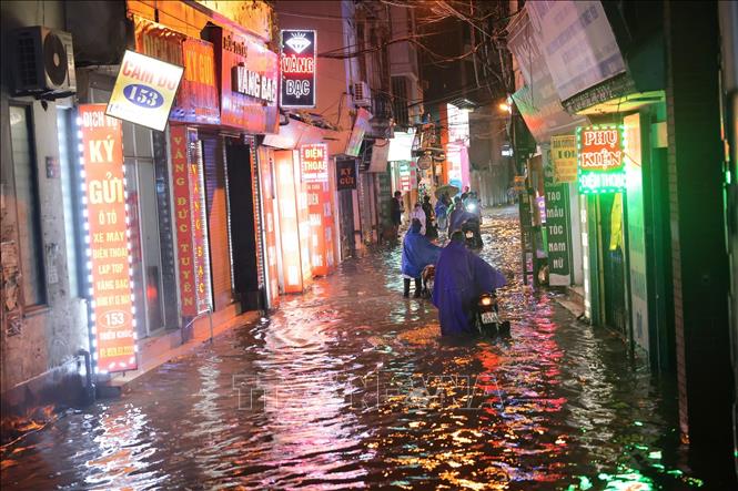 Nước ngập sâu khiến nhiều xe bị chết máy phải dắt bộ. Ảnh: Hoàng Hiếu - TTXVN