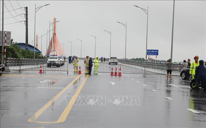 Các lực lượng chức năng lập chốt cấm các phương tiện lưu thông qua cầu. Ảnh: Tạ Toàn – TTXVN