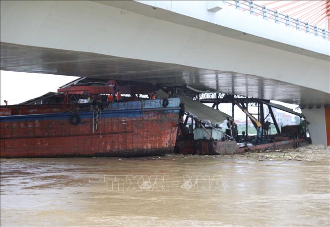Tàu chở hàng và sà lan bị mắc kẹt dưới gầm cầu Vĩnh Phú. Ảnh: Tạ Toàn – TTXVN