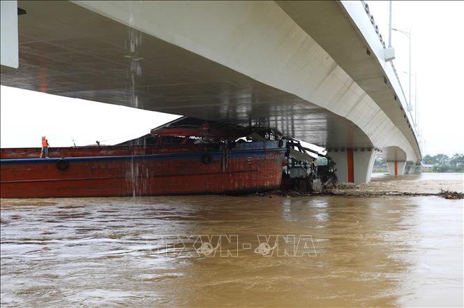 Một tàu chở hàng và sà lan bị mắc kẹt dưới gầm cầu Vĩnh Phú. Ảnh: Tạ Toàn – TTXVN
