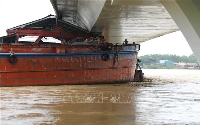 Một tàu chở hàng và sà lan bị mắc kẹt dưới gầm cầu Vĩnh Phú. Ảnh: Tạ Toàn – TTXVN
