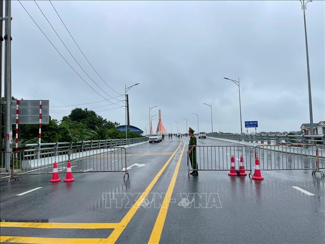 Lực lượng chức năng tỉnh Phú Thọ và tỉnh Vĩnh Phúc tạm cấm phương tiện di chuyển qua cầu để đảm bảo an toàn. Ảnh: TTXVN phát