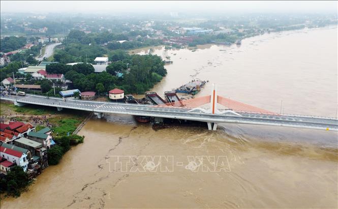 Nhiều tàu chở hàng và sà lan bị mắc kẹt dưới chân cầu Vĩnh Phú thuộc địa bàn phường Dữu Lâu, thành phố Việt Trì (Phú Thọ) sáng 10/9/2024. Ảnh: Tạ Toàn - TTXVN