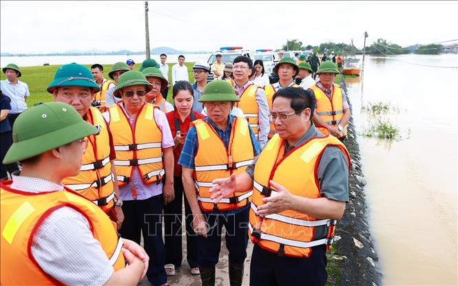 Thủ tướng Phạm Minh Chính kiểm tra tình trạng ngập lụt tại xã Vân Hà, thị xã  Việt Yên, tỉnh Bắc Giang. Ảnh: Dương Giang-TTXVN