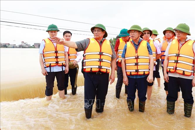 Thủ tướng Phạm Minh Chính kiểm tra tình trạng ngập lụt tại xã Vân Hà, thị xã Việt Yên, tỉnh Bắc Giang. Ảnh: Dương Giang-TTXVN