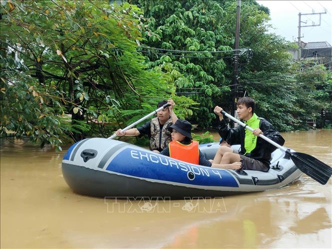 Lực lượng cứu hộ đưa người dân ra khỏi khu vực ngập úng. Ảnh: Tuấn Anh - TTXVN