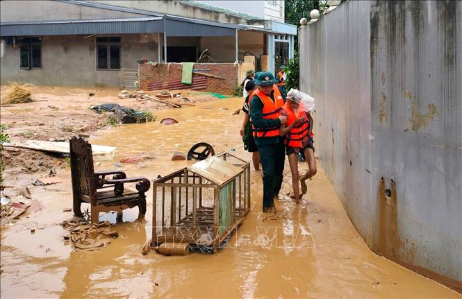 Lực lượng quân đội đưa người dân ra khỏi khu vực nguy hiểm. Ảnh: Tuấn Anh - TTXVN