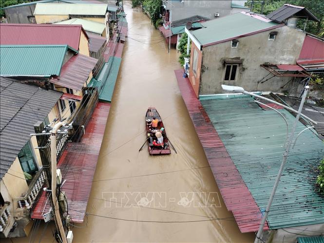 Lực lượng cứu hộ đưa người dân ra khỏi khu vực ngập úng tại đường Thanh Niên, phường Hồng Hà. Ảnh: Tuấn Anh - TTXVN