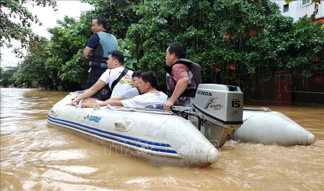 Lực lượng cứu hộ đưa người dân ra khỏi khu vực ngập lụt. Ảnh: Tuấn Anh - TTXVN