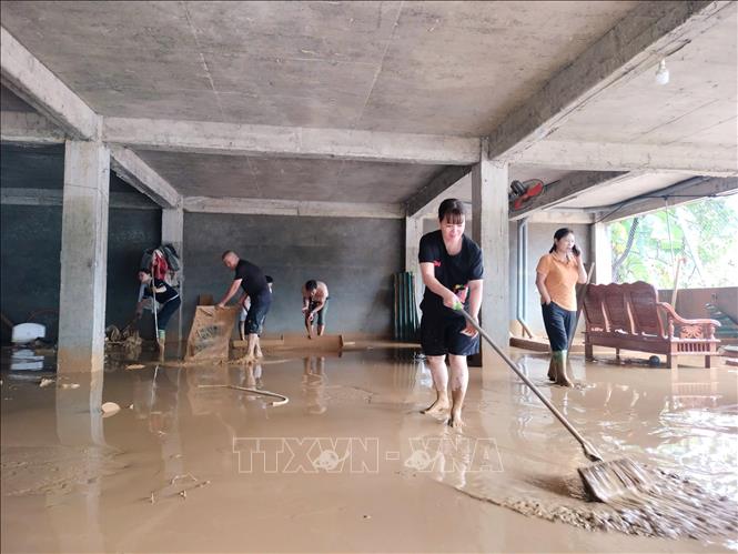 Người dân tranh thủ dọn dẹp nhà cửa sau khi nước rút. Ảnh: Tuấn Anh - TTXVN