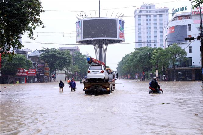 Xe ô tô bị chết máy khi đi qua khu vực bị ngập. Ảnh: Quang Cường - TTXVN