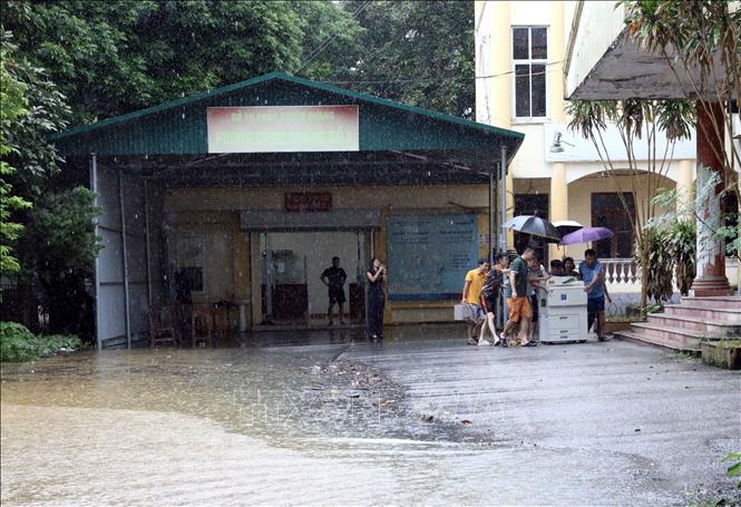 Nhiều cơ quan, đơn vị di chuyển máy móc đến nơi khô ráo. Ảnh: Quang Cường - TTXVN