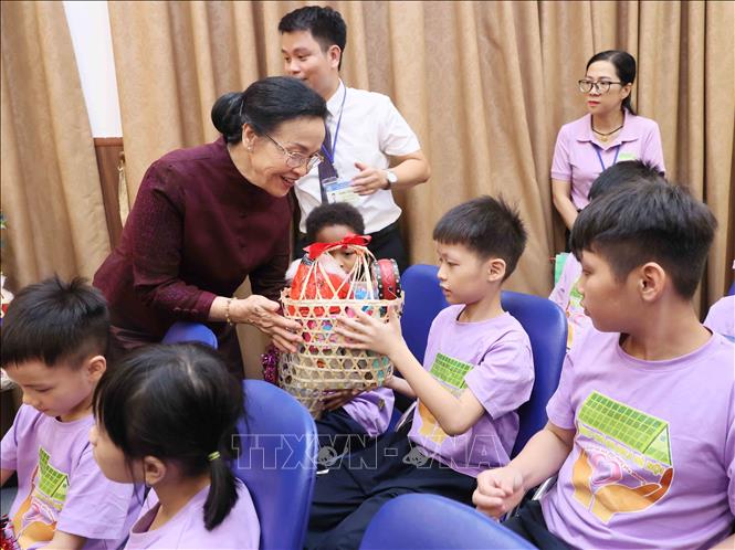 Phu nhân Tổng Bí thư, Chủ tịch nước Lào Thongloun Sisoulith, bà Naly Sisoulith phát quà Trung thu cho các cháu của Làng trẻ em Birla Hà Nội. Ảnh: An Đăng - TTXVN
