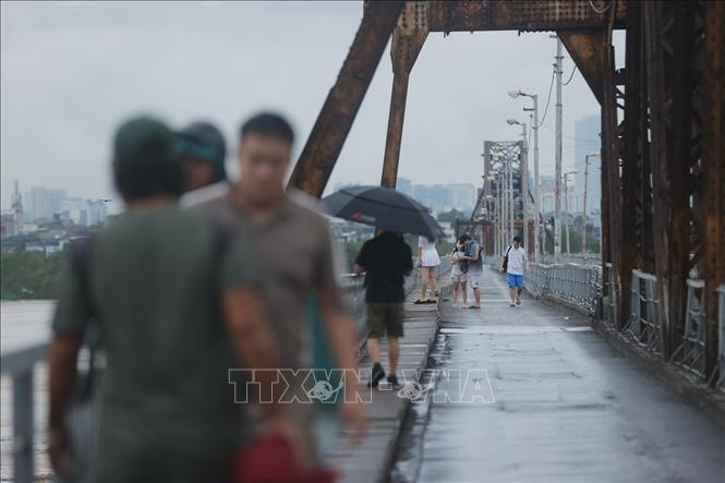 Nhiều người chọn phương án đi bộ qua cầu Long Biên trước khi lệnh cấm chính thức có hiệu lực. Ảnh: Minh Quyết - TTXVN