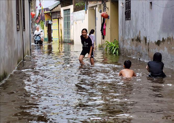 Trẻ em không tới trường, vì ngập lụt nhưng lại vui chơi trong nước cũng dễ gây nguy hiểm. Ảnh: Thanh Tùng - TTXVN