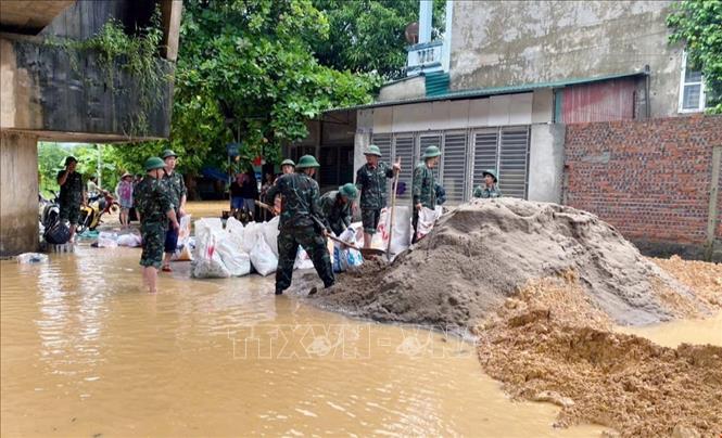 Soldiers assist people to embank causeways to prevent floods in Ha Hoa district, Phu Tho province. VNA Photo