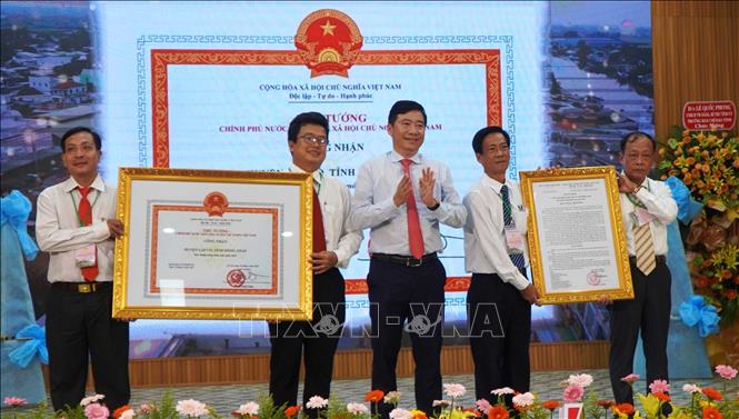 Thừa ủy quyền Thủ tướng Chính phủ, Chủ tịch UBND tỉnh Đồng Tháp Phạm Thiện Nghĩa trao Quyết định và Bằng công nhận huyện Lấp Vò đạt chuẩn nông thôn mới. Ảnh: Nhựt An - TTXVN