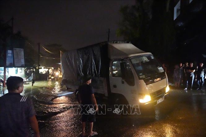 Người dân di chuyển xe tải khỏi khu vực bến đỗ xe 46 Chương Dương Độ, quận Hoàn Kiếm trong đêm 9/9. Ảnh: Phạm Tuấn Anh - TTXVN