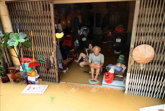 Những người cao tuổi như người đàn ông này ở phố Phúc Tân, phường Phúc Tân, quận Hoàn Kiếm dù đã từng quen với cảnh nước ngập trên phố, tràn vào nhà nhưng chắc cũng không khỏi bất ngờ bởi trận lũ này quá lớn. (ảnh chụp lúc 14h ngày 11/9). Ảnh: An Đăng-TTXVN