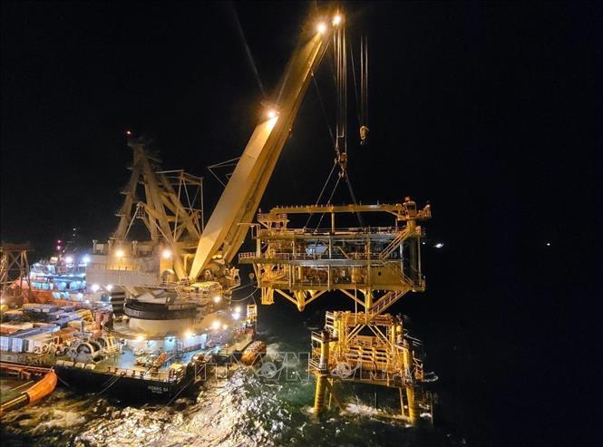 Workers use a crane vessel to install the 760-tonne block. VNA Photo