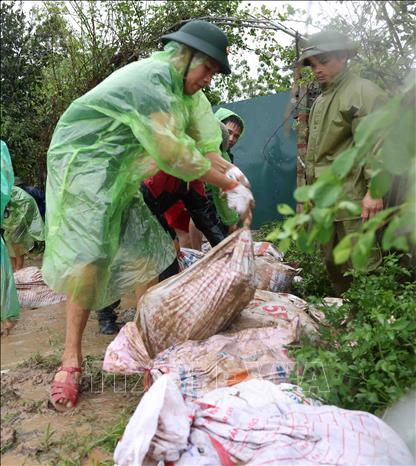 Quân đội và người dân thôn Liệp Mai, xã Ngọc Liệp, huyện Quốc Oai khẩn trương gia cố đoạn đê bao sông Tích. Ảnh: Vũ Sinh - TTXVN