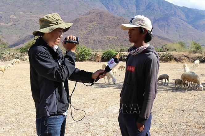 Phóng viên Nguyễn Thành phỏng vấn người chăn nuôi gia súc tại xã Phước Trung, huyện Bác Ái, tỉnh Ninh Thuận giữa mùa hạn hán 2020. Ảnh: TTXVN