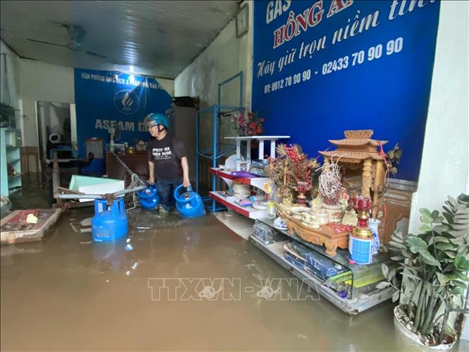 Người dân di chuyển đồ đạc lên cao để tránh ngập. Ảnh: Vũ Sinh - TTXVN