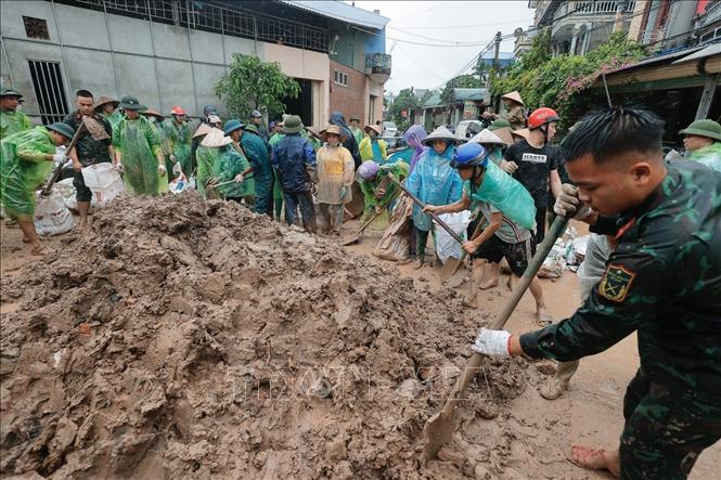 Chiến sĩ Trung đoàn 102 và người dân chuẩn bị bao tải đất để gia cố đê sông Tích, ngăn nước tràn qua đê. Ảnh: Minh Quyết - TTXVN