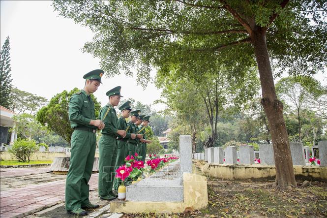 Cán bộ, chiến sĩ chăm sóc các ngôi mộ tại Nghĩa trang liệt sĩ Đồi 82, Tây Ninh. Ảnh: Giang Phương - TTXVN