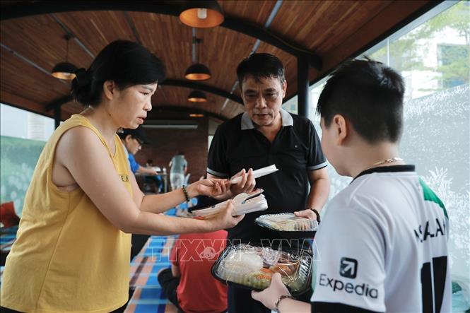 Cán bộ Hội Chữ thập phường Chương Dương phát cơm cho người dân đang tránh lũ. Ảnh: Minh Quyết - TTXVN
