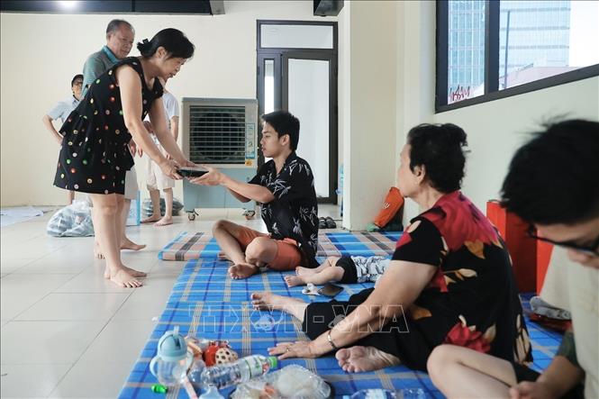 Các lực lượng phường Chương Dương hỗ trợ người dân nơi tránh lũ. Ảnh: Minh Quyết - TTXVN