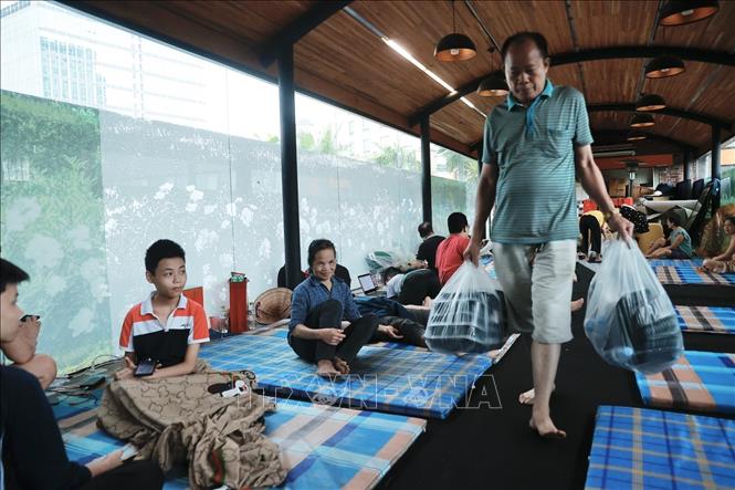 Thành viên Hội Cựu chiến binh phường Chương Dương hỗ trợ phát cơm cho người dân. Ảnh: Minh Quyết - TTXVN