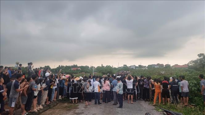 Rất đông người dân hiếu kỳ kéo đến nghĩa trang Triều Công (xã Quảng Lộc) theo dõi cơ quan chức năng khám nghiệm hiện trường. Ảnh: TTXVN phát