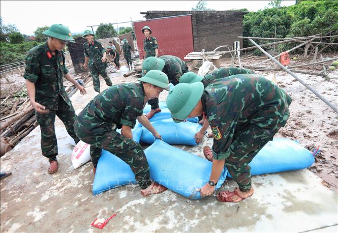 Cán bộ, chiến sĩ Sư đoàn 325 hỗ trợ gia đình anh Nguyễn Văn Hồng, thôn Thủ Dương xã Nam Dương  bị sập nhà cấp 4, diện tích 200m2, do nước lên chạy không kịp. Ảnh: Danh Lam -TTXVN