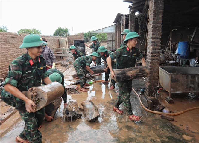 Cán bộ, chiến sĩ Sư đoàn 325 hỗ trợ gia đình anh Nguyễn Văn Hồng, thôn Thủ Dương xã Nam Dương  bị sập nhà cấp 4, diện tích 200m2, do nước lên chạy không kịp. Ảnh: Danh Lam -TTXVN