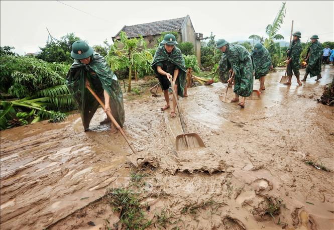 Cán bộ, chiến sĩ Sư đoàn 325 dọn dẹp sình lầy tại thôn Khả Lã, xã Tân Lập, huyện Lục Ngạn. Ảnh: Danh Lam -TTXVN