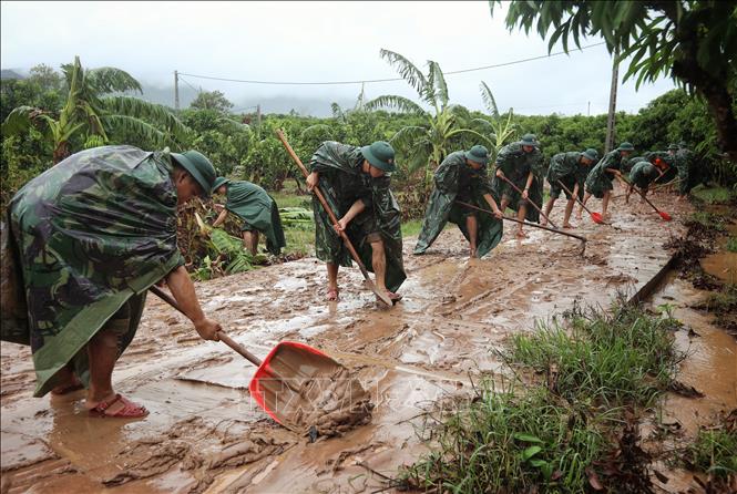 Cán bộ, chiến sĩ Sư đoàn 325 dọn dẹp sình lầy tại thôn Khả Lã, xã Tân Lập, huyện Lục Ngạn. Ảnh: Danh Lam - TTXVN