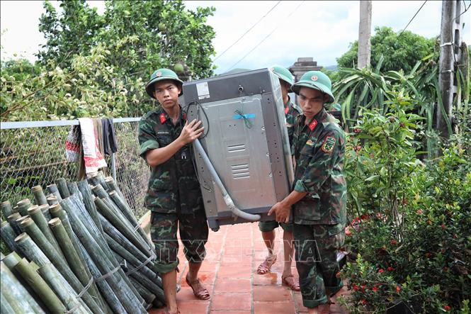 Cán bộ, chiến sĩ Sư đoàn 325 giúp dân vận chuyển đồ đạc tại thôn Khả Lã, xã Tân Lập, Lục Ngạn. Ảnh: Danh Lam - TTXVN