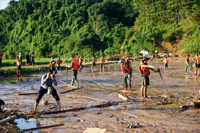 Phóng viên Dương Giang (Ban Biên tập Ảnh) tác nghiệp tại khu vực sạt lở đất ở làng Nủ, xã Phúc Khánh, huyện Bảo Yên, tỉnh Lào Cai (12/9/2024). Ảnh: TTXVN
