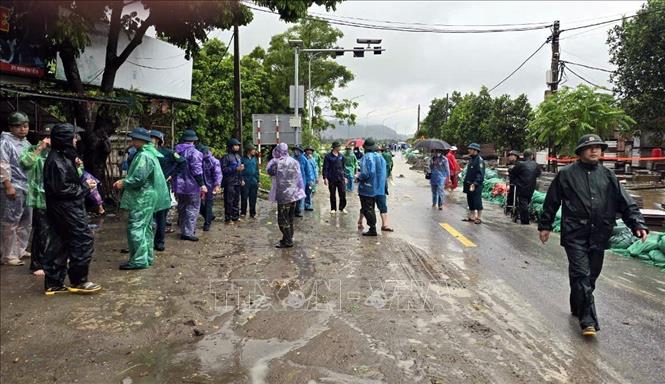 Lượng chức năng xã và huyện Ứng Hòa đang tập trung ứng phó, đắp tải cát để bảo vệ những điểm xung yếu tại đập tràn Dốc Bồ. Ảnh: Nguyễn Văn Cảnh-TTXVN